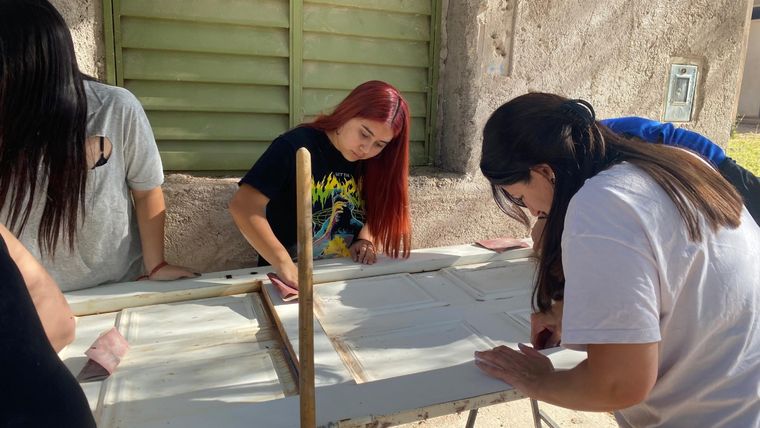 Voluntarios ayudan a reparar el frente del merendero para resguardar a los niños del frío. Foto: Gentileza