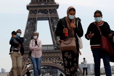 Personas con mascarilla caminan por la plaza Trocadero, cerca de la Torre Eiffel, en París (Francia), el 16 de mayo de 2020.