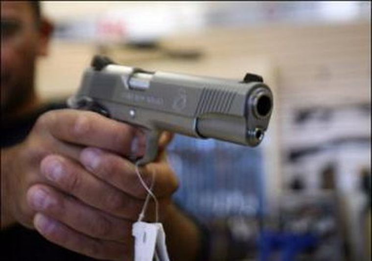 Un hombre comprando un arma. Foto: AFP